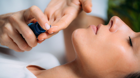 Woman having cream applied to her face